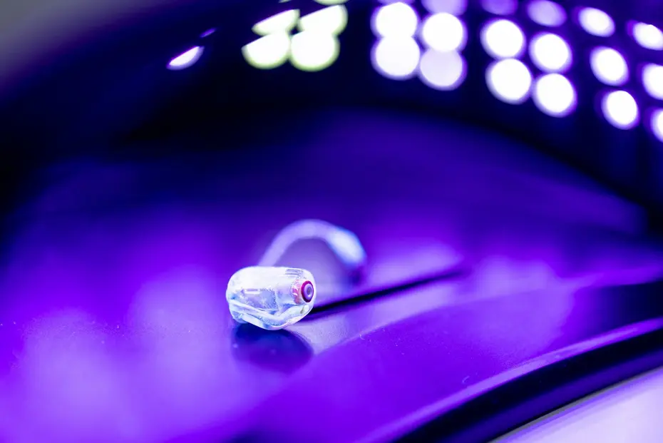 Small component on a surface under a violet-glowing UVC LED array during irradiation